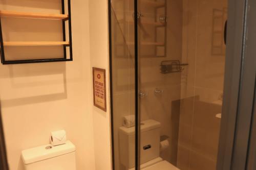 a bathroom with a toilet and a glass shower at Apartamento Palmeiras in Sao Paulo