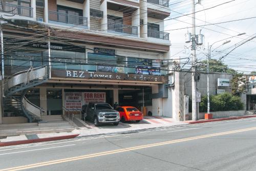 two cars parked in front of a building at RedDoorz Plus @ Bez Tower and Residences San Juan in Manila
