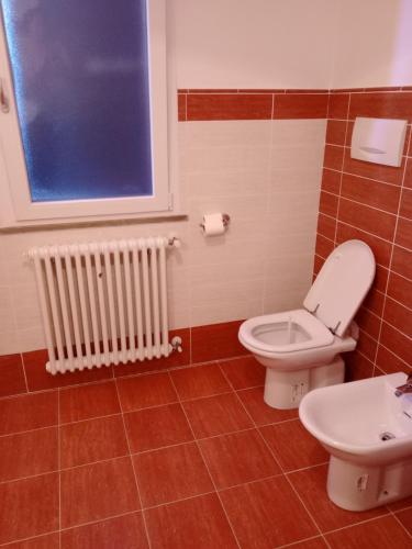 La salle de bains est pourvue de toilettes, d'un lavabo et d'une fenêtre. dans l'établissement B&b Serena, à Roncofreddo