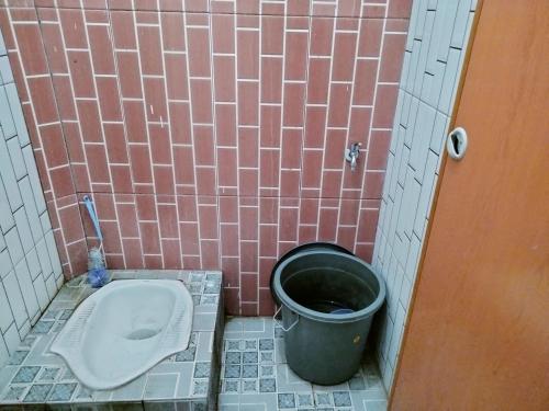 een badkamer met een toilet en een emmer bij SPOT ON 92749 As-sakinah Syariah 2 in Medan