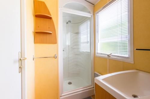 a bathroom with a shower and a white sink at Camping des Templiers in Le Caylar