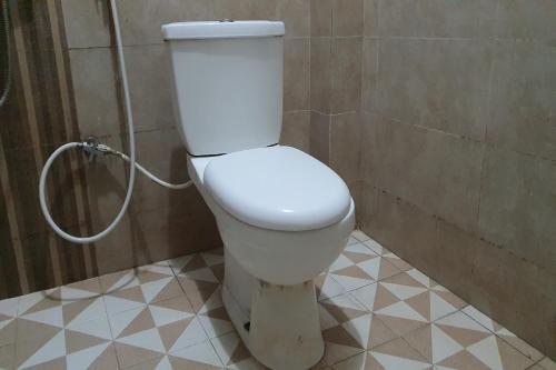 a white toilet in a bathroom with a shower at OYO 92751 Marang Homestay Syariah 