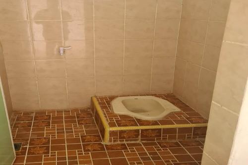 y baño con aseo en el suelo de baldosa. en SPOT ON 92697 Ani Nur Homestay Syariah, en Medan