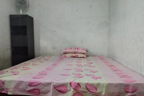 Una cama con pétalos rosas en una habitación en SPOT ON 92697 Ani Nur Homestay Syariah, en Medan
