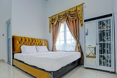 ein Schlafzimmer mit einem großen Bett und einem Fenster in der Unterkunft OYO 92708 Hotel Mufasa Syariah in Pangkalpinang