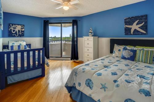 een slaapkamer met blauwe muren en een bed met een wieg bij Seahorse 401 in Clearwater Beach