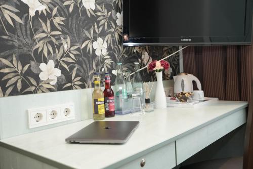 a desk with a laptop and bottles of alcohol on it at Hotel Attaché an der Messe in Frankfurt/Main