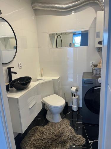 a white bathroom with a sink and a toilet at Apartament Mazurski Sen in Giżycko