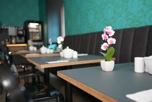 a row of tables with pink flowers on them at Hotel Attaché an der Messe in Frankfurt/Main