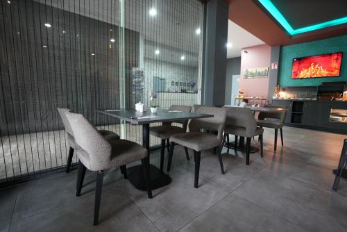 フランクフルト・アム・マインにあるホテル アタッシェ アン デア メッセのテーブルと椅子、テレビ付きのレストラン