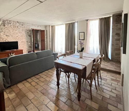 een woonkamer met een tafel en een bank bij Le Mansarine Charme B&B in Castellaro