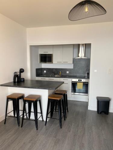 une cuisine avec un grand comptoir et des tabourets. dans l'établissement Splendide vue dans ce studio !, à Ajaccio