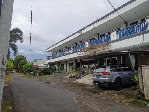 un coche plateado estacionado frente a un edificio en SPOT ON 92782 Rumah Kost Kita Tarakan, en Tarakan