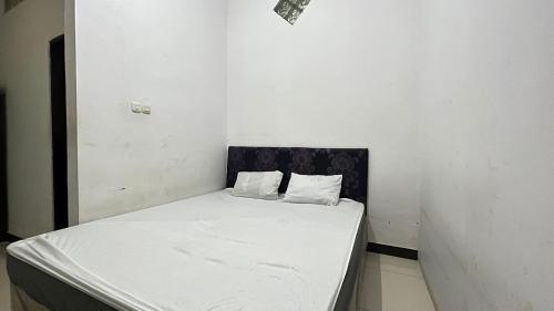 een wit bed met 2 kussens in een kamer bij SPOT ON 92776 Panorama House in Tomohon