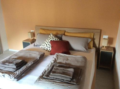 een slaapkamer met een bed met kussens erop bij Al Borgo Appartamento in Venzone