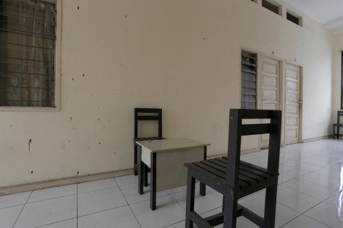 a room with a table and a chair in it at Hotel O Rumah Kost Kita Tarakan in Tarakan