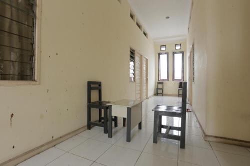 a room with a table and two chairs in it at Hotel O Rumah Kost Kita Tarakan in Tarakan