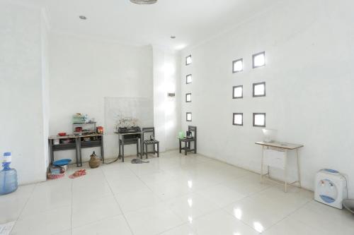 a large white room with tables and chairs in it at Hotel O Rumah Kost Kita Tarakan in Tarakan