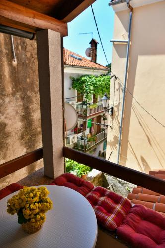 a table with a vase of flowers on a balcony at Apartments Dolores Old Town in Mošćenička Draga