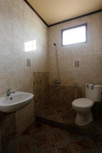 a bathroom with a sink and a toilet and a window at Hotel O Rumah Kost Kita Tarakan in Tarakan