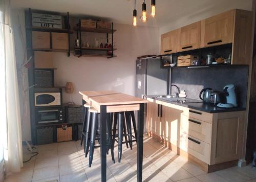 uma cozinha com uma mesa e um frigorífico em Super nid douillet vue imprenable mer et piscine em Serra-di-Ferro