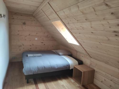 a bedroom with a bed in a wooden cabin at Le chalet à comté in Saffloz