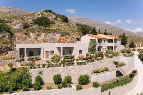 a house with a stone wall at Villa Stella Suites in Plakias