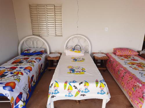 2 łóżka pojedyncze w pokoju z: w obiekcie Casa de campo w mieście Barra do Garças