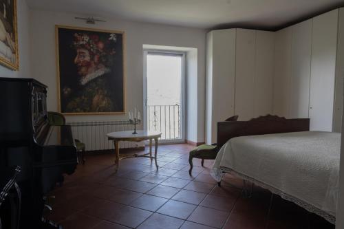 um quarto com uma cama, uma mesa e uma janela em La Casa di Penelope & Cirene em Pietrapertosa