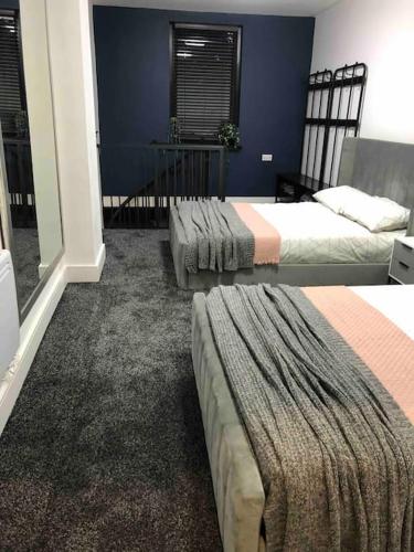 Duas camas num quarto com paredes azuis em The Old Bakery, NEC, BHX, HS2, Birmingham em Birmingham