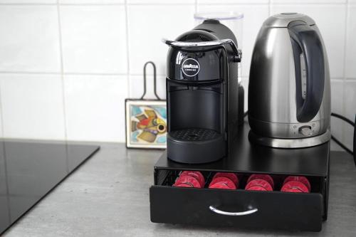 a coffeemaker sitting on top of a black stand in a kitchen at Eiffel Tower Appartment in Paris