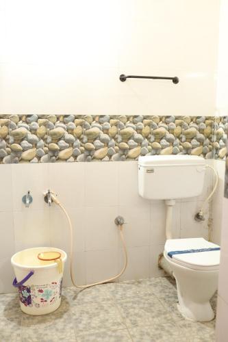 a bathroom with a toilet and a shower in it at Hotel Sri Balaji in Ooty