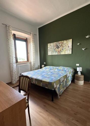 een slaapkamer met een bed, een tafel en een raam bij Affittacamere La Rondinella in Montemerano