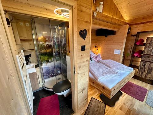 a small room with a bed and a shower at Tiny House Singer - contactless check-in - Sauna in Ehenbichl