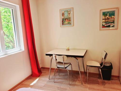 une table et des chaises dans une pièce avec une fenêtre dans l'établissement Mauvaise annonce, à Toulon