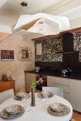 a table with plates and glasses on it in a kitchen at La Longère de l'Amiral c'est au choix la Maison de l'Amiral jusqu'à 10 personnes ou le Carré de l'Amiral jusqu'à 4 personnes in Moëlan-sur-Mer