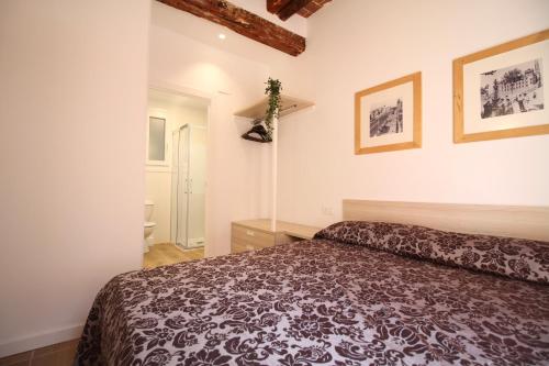 1 dormitorio con 1 cama y 2 cuadros en la pared en Espinach Port Serrallo en Tarragona