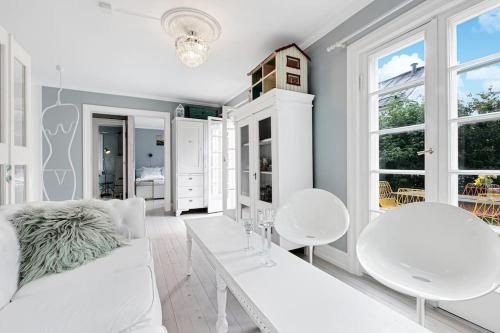 a white living room with white chairs and a white couch at Leilighet på Smestad in Oslo