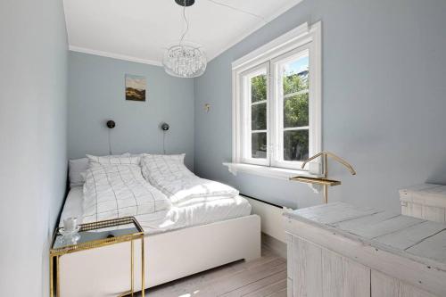 a white bedroom with a bed and a window at Leilighet på Smestad in Oslo