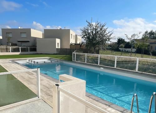 une grande piscine devant une maison dans l'établissement Le rêve au soleil les pieds dans l'eau - Villa 6 personnes en résidence avec piscine à 700 m des plages, à Sérignan