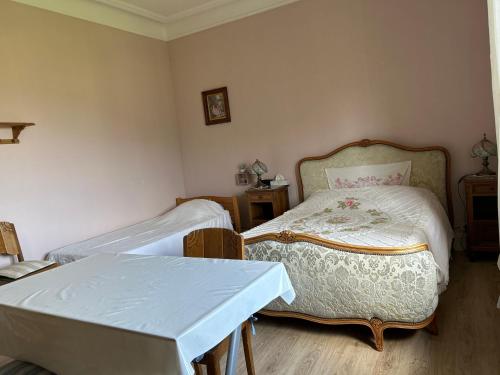 a small room with two beds and a table at Chambre Gentiane 2 à 3 personnes wifi sdb partagée in Saint-Amarin