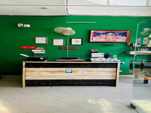 una pared verde con un mostrador en una tienda en OYO Flagship 12976 Hotel New Fiza, en Jammu