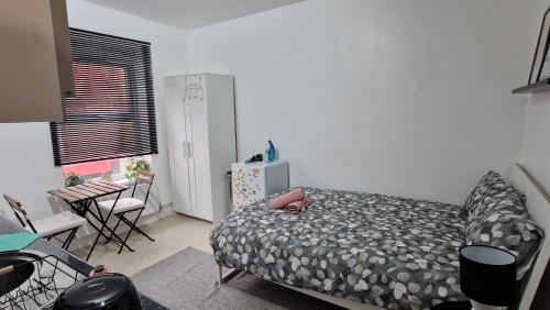 a bedroom with a bed and a table and chairs at SMALL COZY STUDIO ZONE 1 LONDON in London