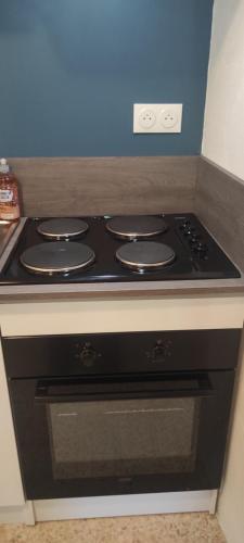 La cuisine est équipée d'un four avec plaques de cuisson noires. dans l'établissement Le Nid du Rossignol, à Nîmes