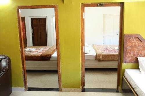 a room with two mirrors and a room with two beds at Hotel Sri Balaji in Ooty