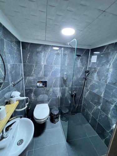 a bathroom with a shower and a toilet and a sink at Hayde otel in Çamlıhemşin