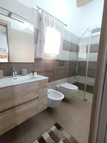 a bathroom with a sink and a toilet and a shower at Appartamenti Petali Di Rosa in Custonaci