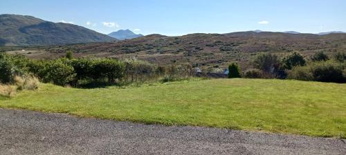 a field of grass with mountains in the background at Skye-Fall in Drumfearn
