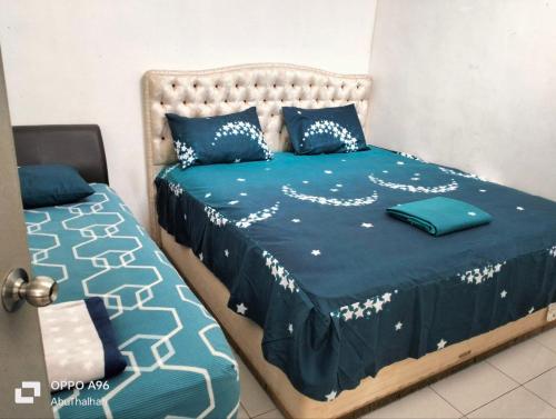 una camera con due letti con lenzuola blu e bianche di Homestay Saujana Harmoni D'Petron a Gua Musang