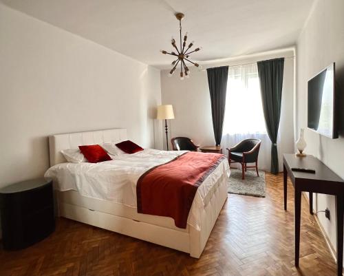 a bedroom with a bed with red pillows and a desk at Dream Home in Turda